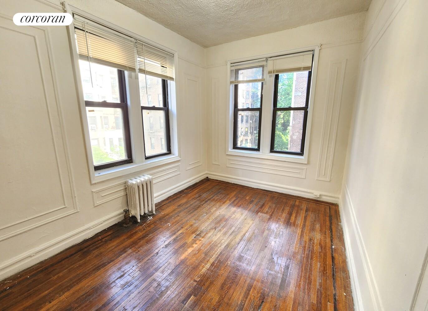 754 Brady Avenue, Unit 303 Bronx, NY 10462 - Photo 9 of 13 an empty room with wooden floor and windows