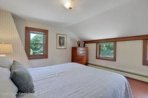 a bedroom with a bed and a window with chair