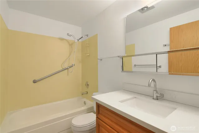 a bedroom with a bed and a lamp on dresser