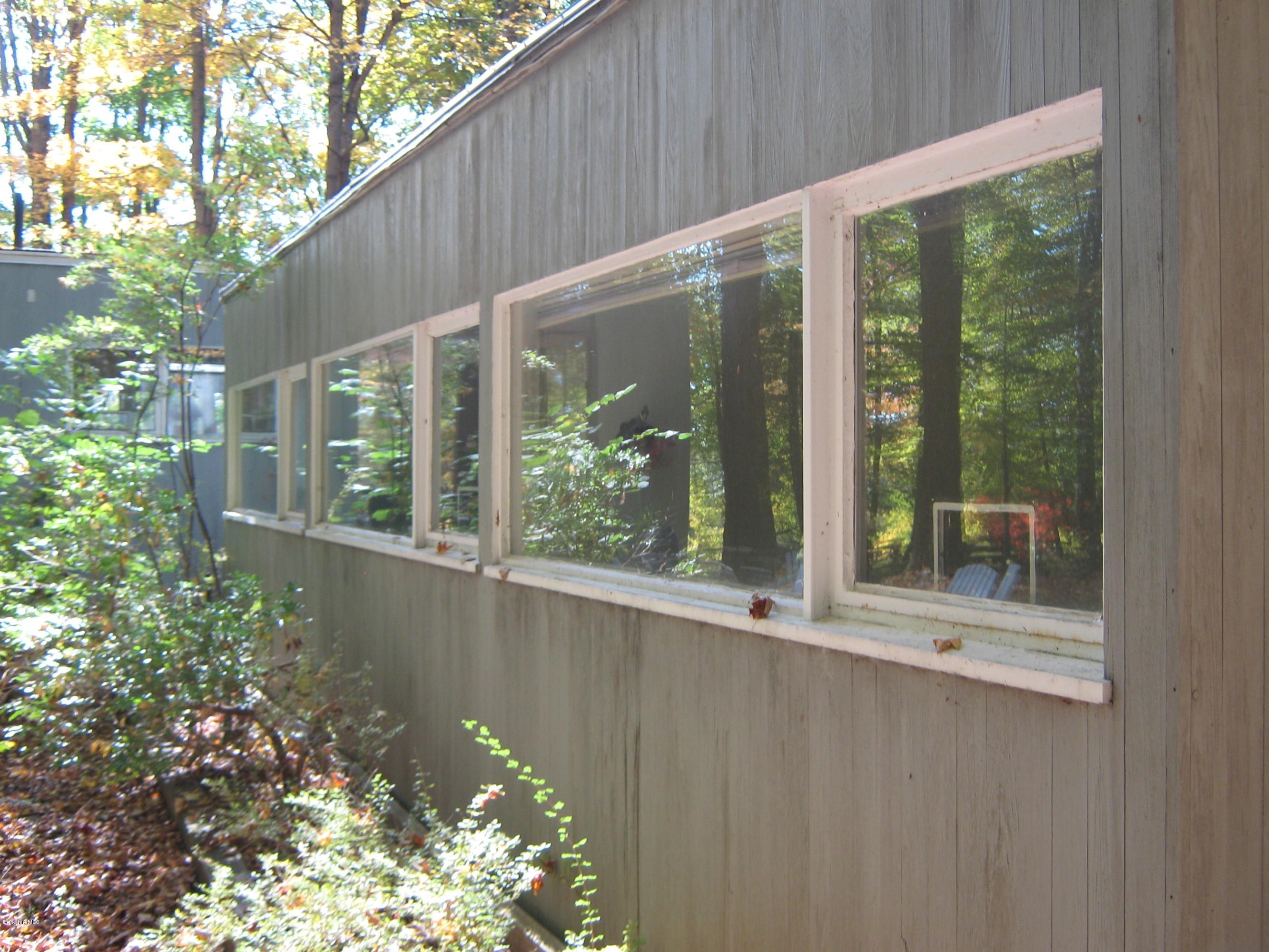 231 Summit Road Richmond, MA 01254 - Photo 17 of 69 a backyard of a house with large windows and plants