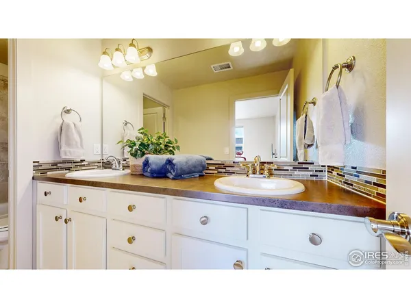 a bathroom with a sink double vanity granite tub shower and a mirror