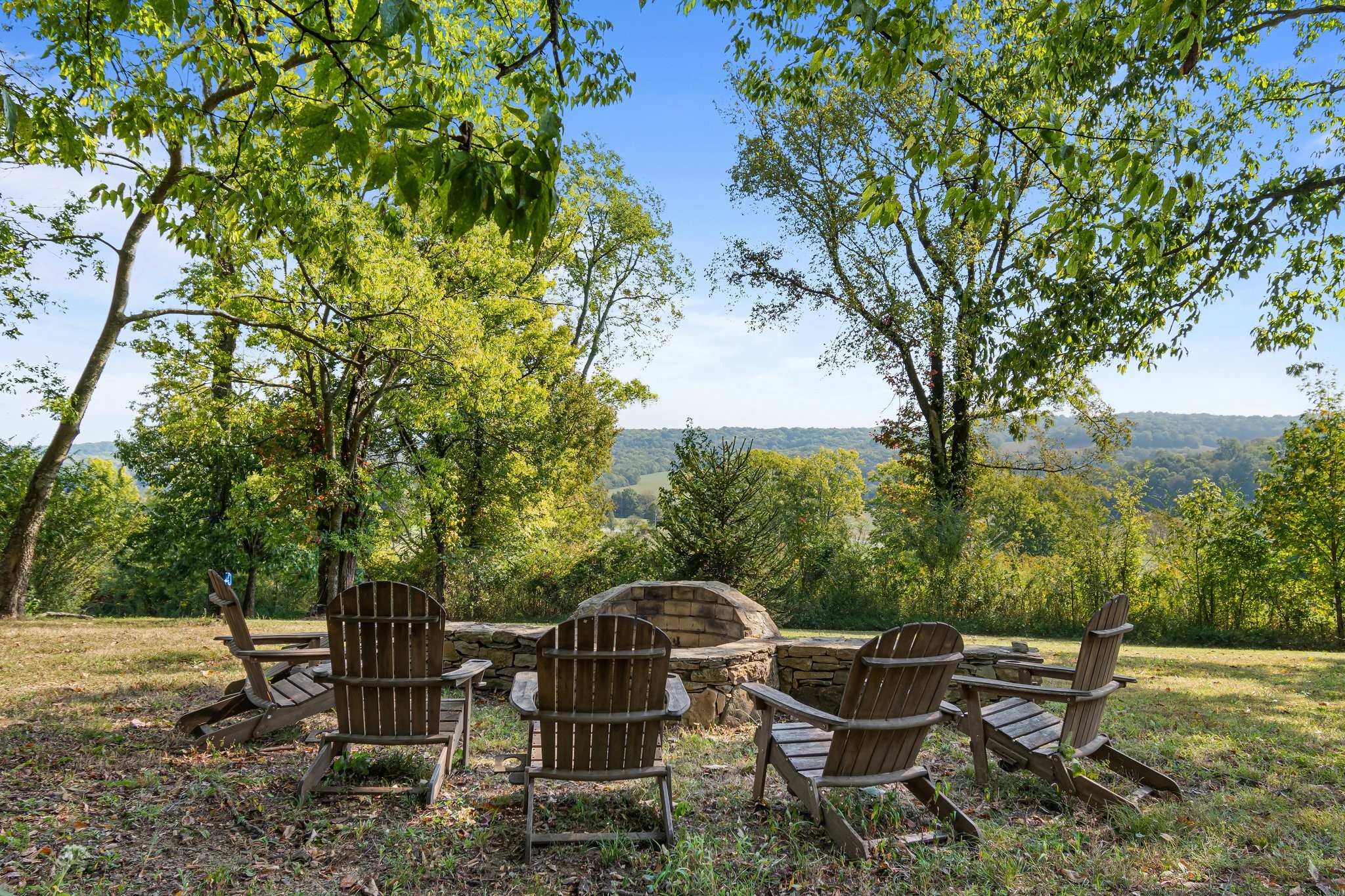 8740 Howell Road Mount Pleasant, TN 38474 - Photo 7 of 70 a backyard of a house with table and chairs under an umbrella
