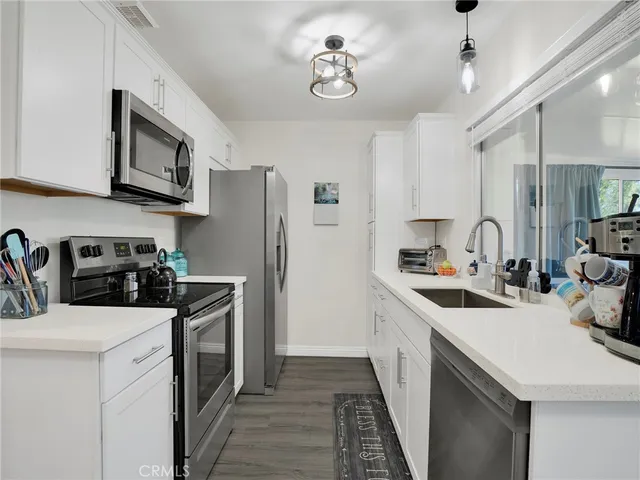 a kitchen with stainless steel appliances a sink stove refrigerator and cabinets