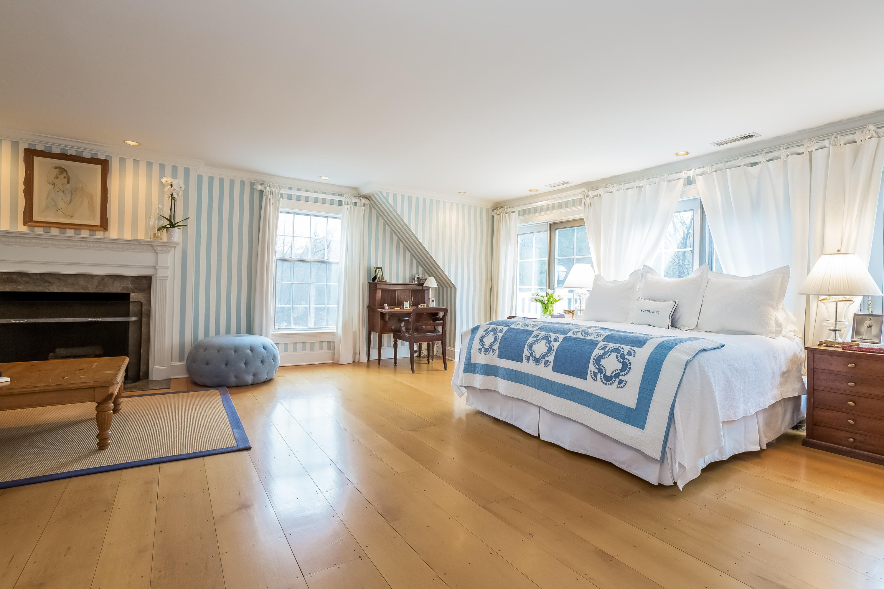 269 Valley Road New Canaan, CT 06840 - Photo 13 of 21 a spacious bedroom with a bed a couch and a chandelier