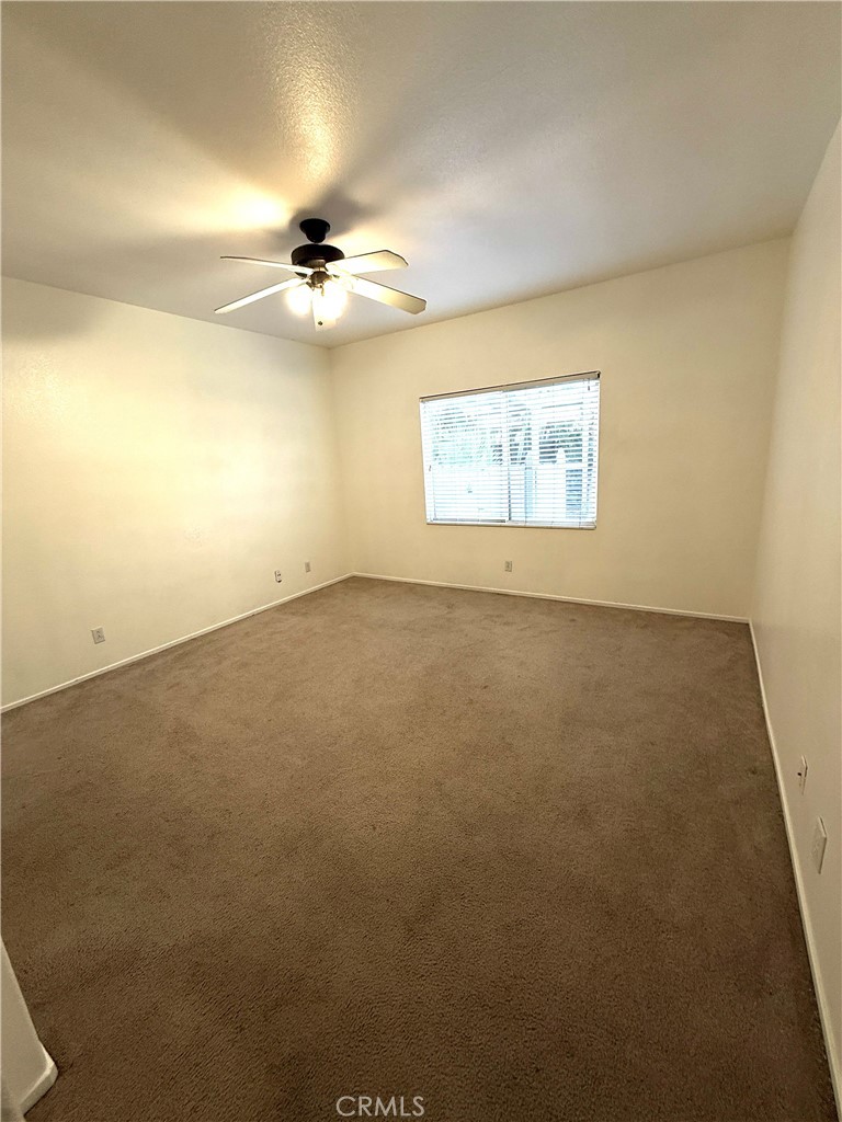 1335 Torrey Pines Court Atwater, CA 95301 - Photo 19 of 28 an empty room with a ceiling fan and window