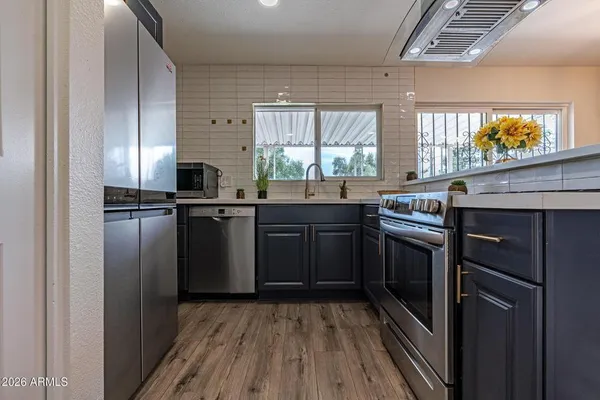 a kitchen with stainless steel appliances granite countertop a stove a sink and a refrigerator