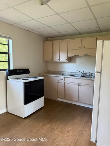 a white kitchen with stainless steel appliances granite countertop a stove a sink and white cabinets