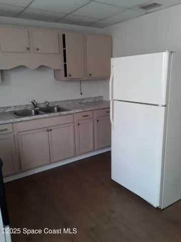 a kitchen with stainless steel appliances granite countertop a refrigerator a stove a sink and white cabinets