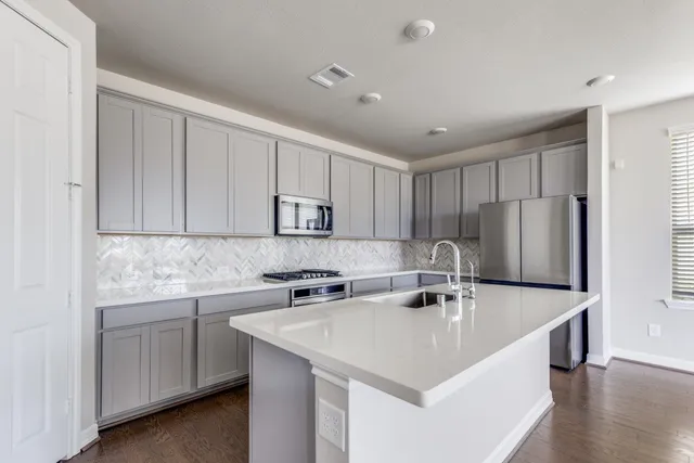 a kitchen with stainless steel appliances granite countertop a sink a microwave and cabinets