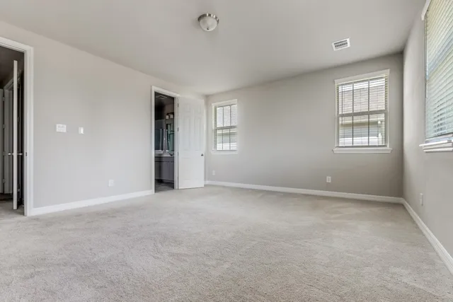 an empty room with windows and closet