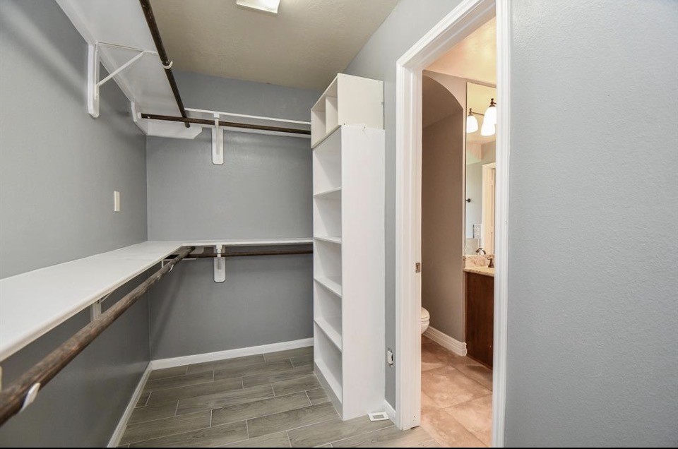 8515 Split Branch Lane Houston, TX 77095 - Photo 18 of 31 a view of walk in closet with empty racks