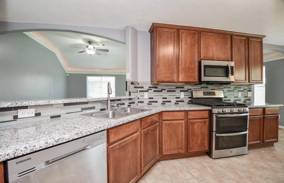 8515 Split Branch Lane Houston, TX 77095 - Photo 8 of 31 a kitchen with stainless steel appliances granite countertop a stove microwave and cabinets
