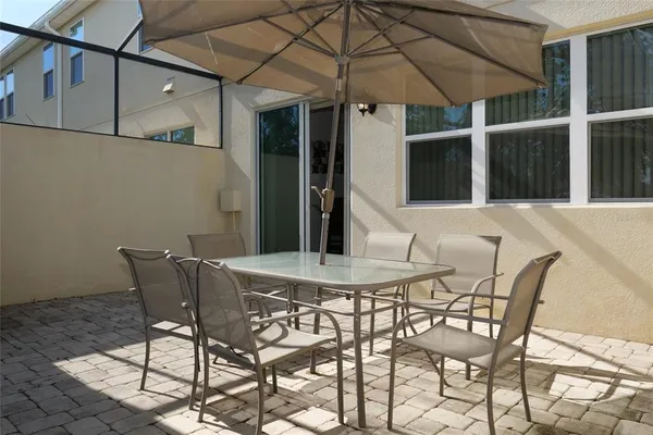 a view of a patio with a table and chairs under an umbrella
