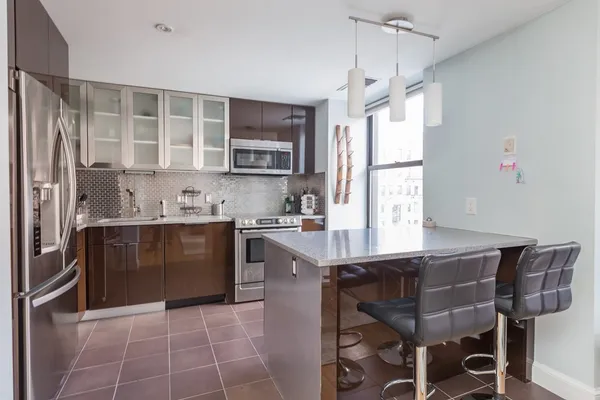 a kitchen with a table chairs refrigerator and microwave