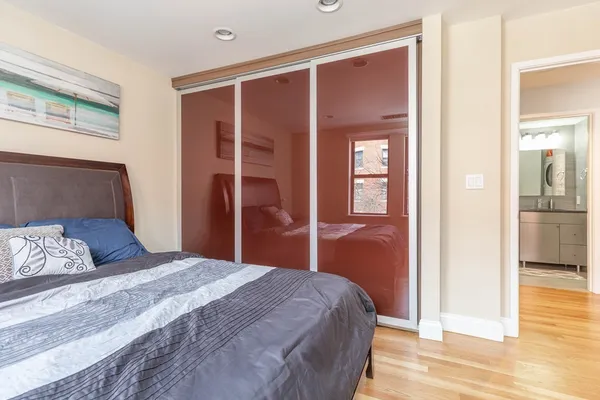 a bedroom with a bed and wooden floor