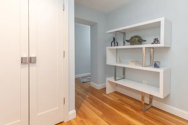 a living room with baby crib and painting on the wall