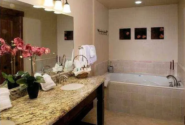 a bathroom with a granite countertop sink a mirror and vanity