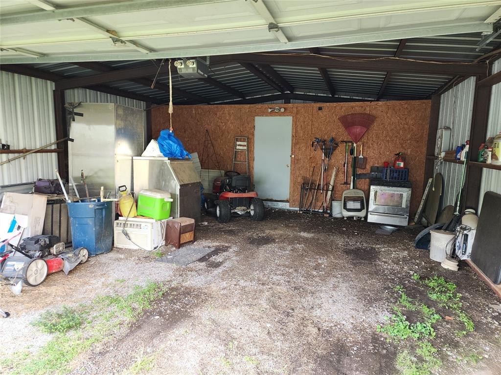 403 Barker Street Cumby, TX 75433 - Photo 10 of 16 Utility building featuring a metal frame, corrugated metal roof, gravel flooring, and a rear door