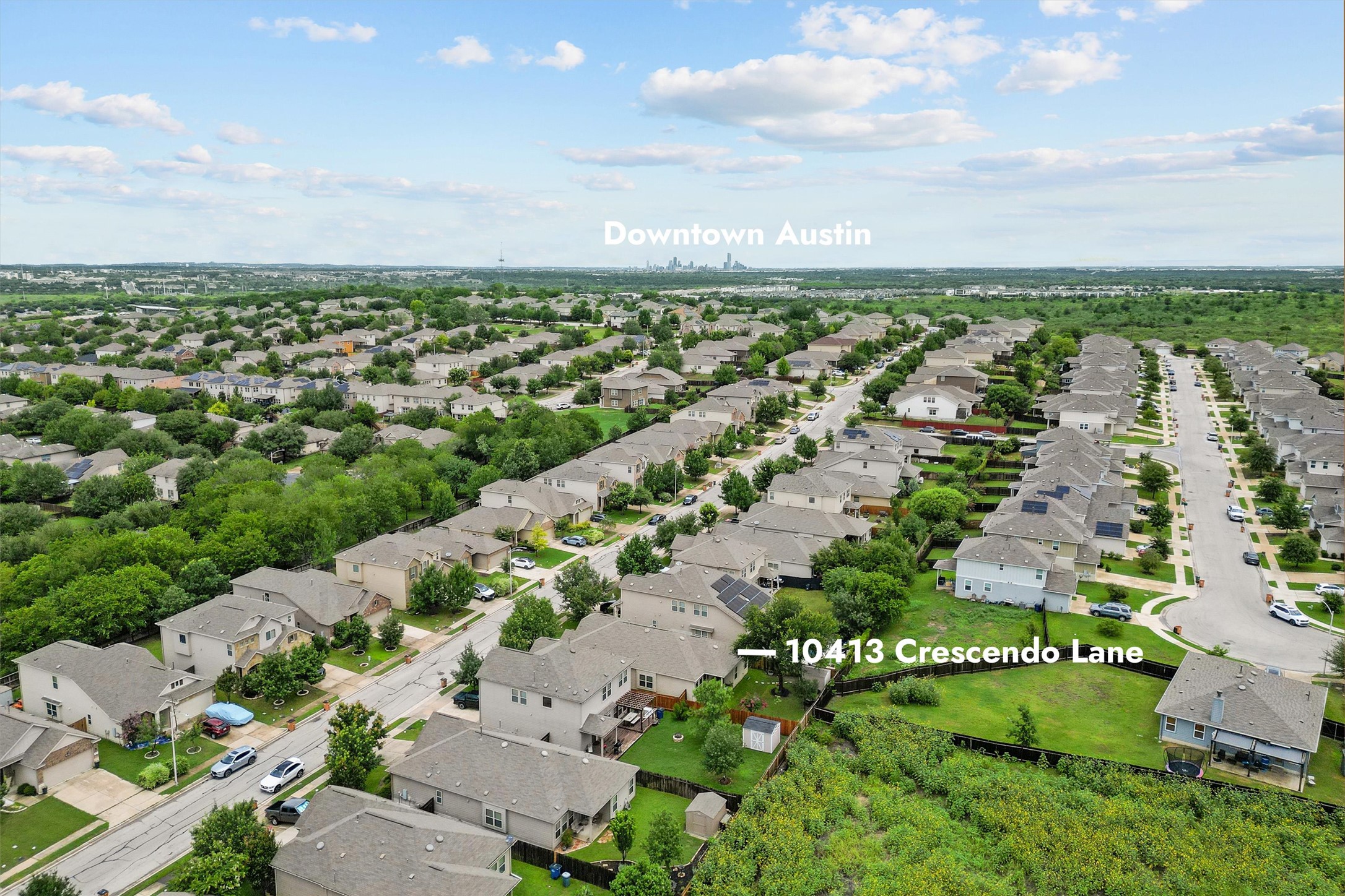 10413 Crescendo Lane Austin, TX 78747 - Photo 30 of 32 An aerial perspective reveals a vibrant neighborhood with residential streets and mature trees, offering distant city views.