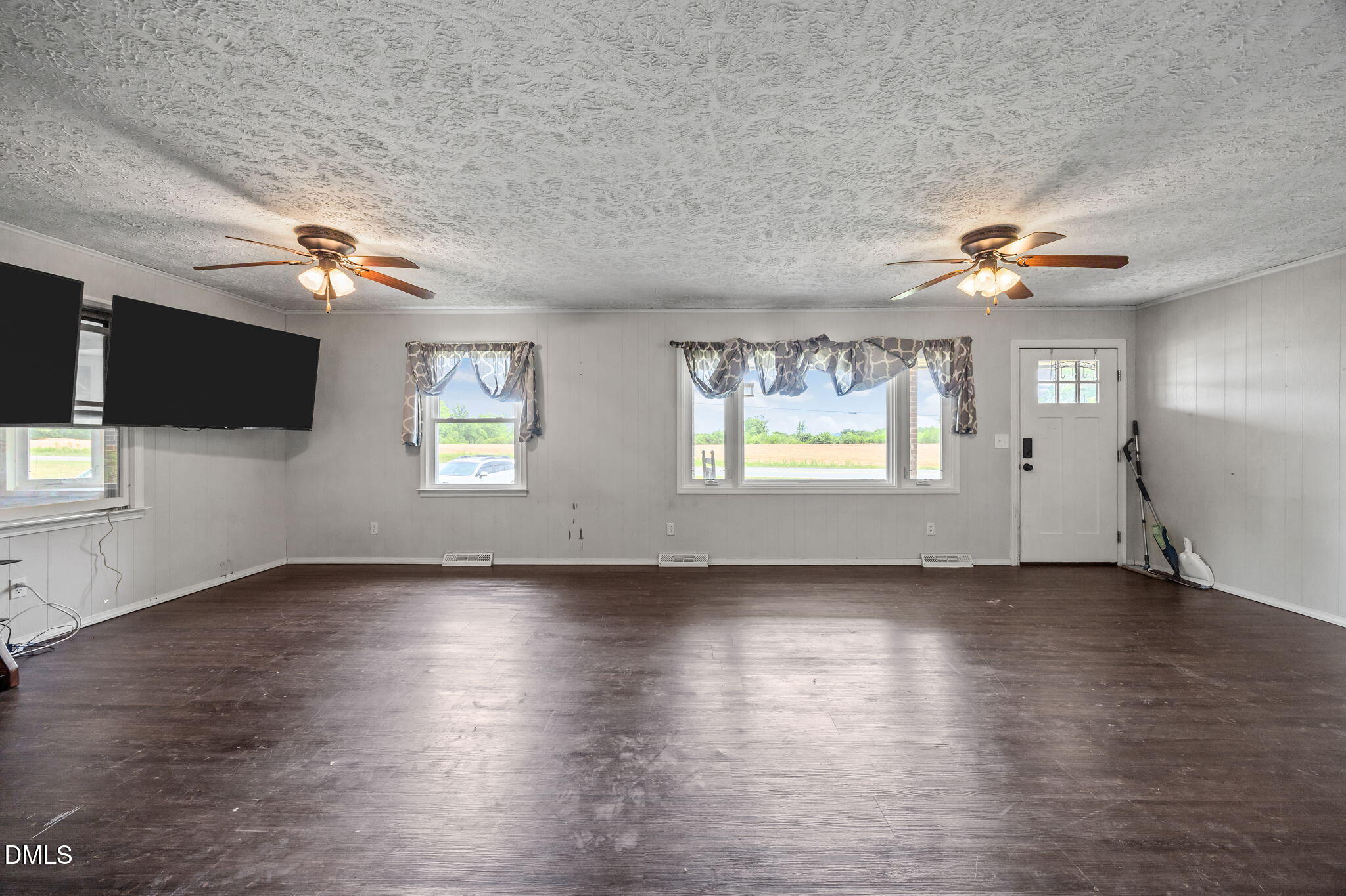786 Dick Holeman Road Timberlake, NC 27583 - Photo 15 of 44 an empty room with wooden floor chandelier fan and windows