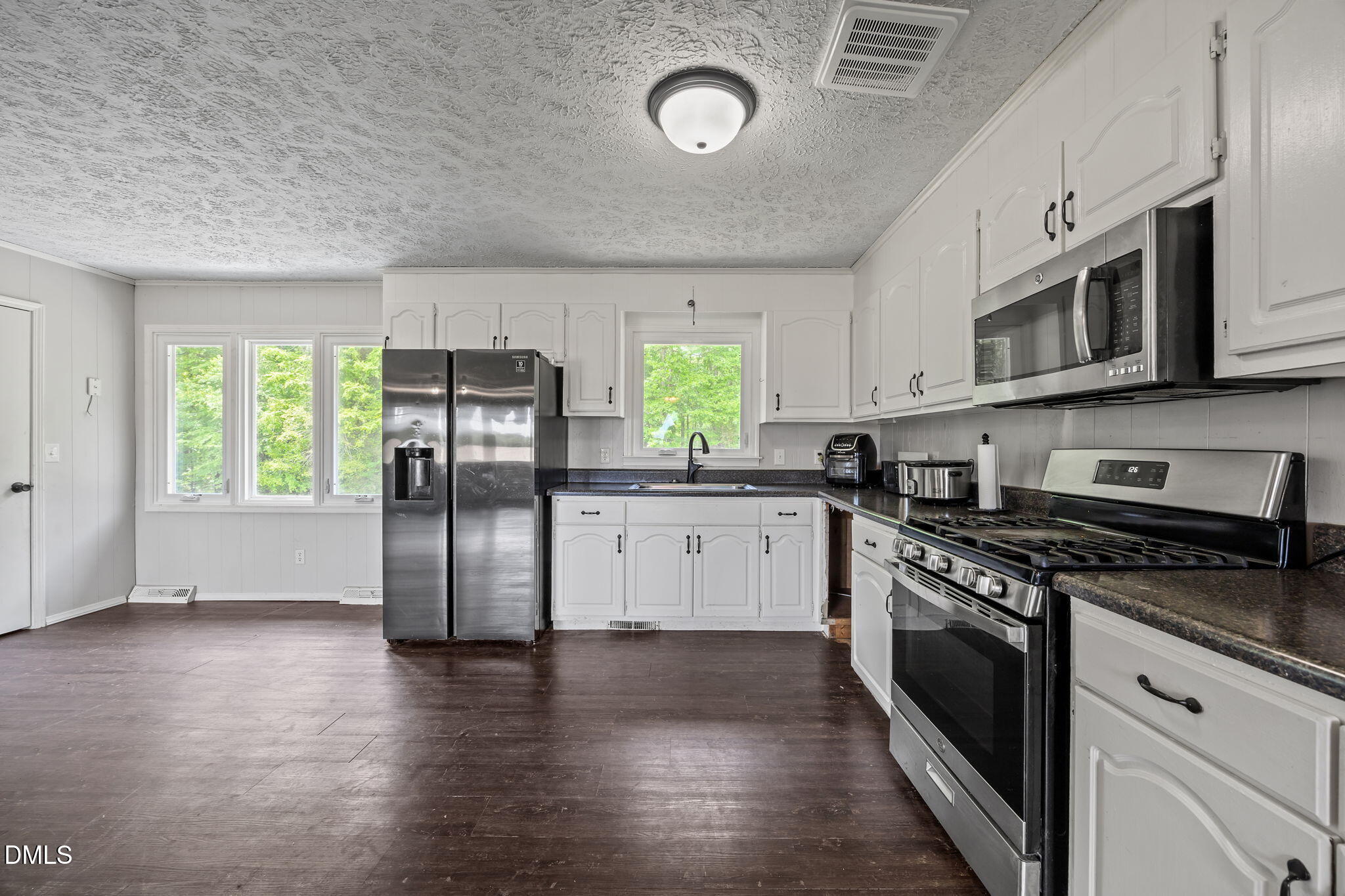 786 Dick Holeman Road Timberlake, NC 27583 - Photo 19 of 44 a kitchen with stainless steel appliances granite countertop a stove a sink and a refrigerator