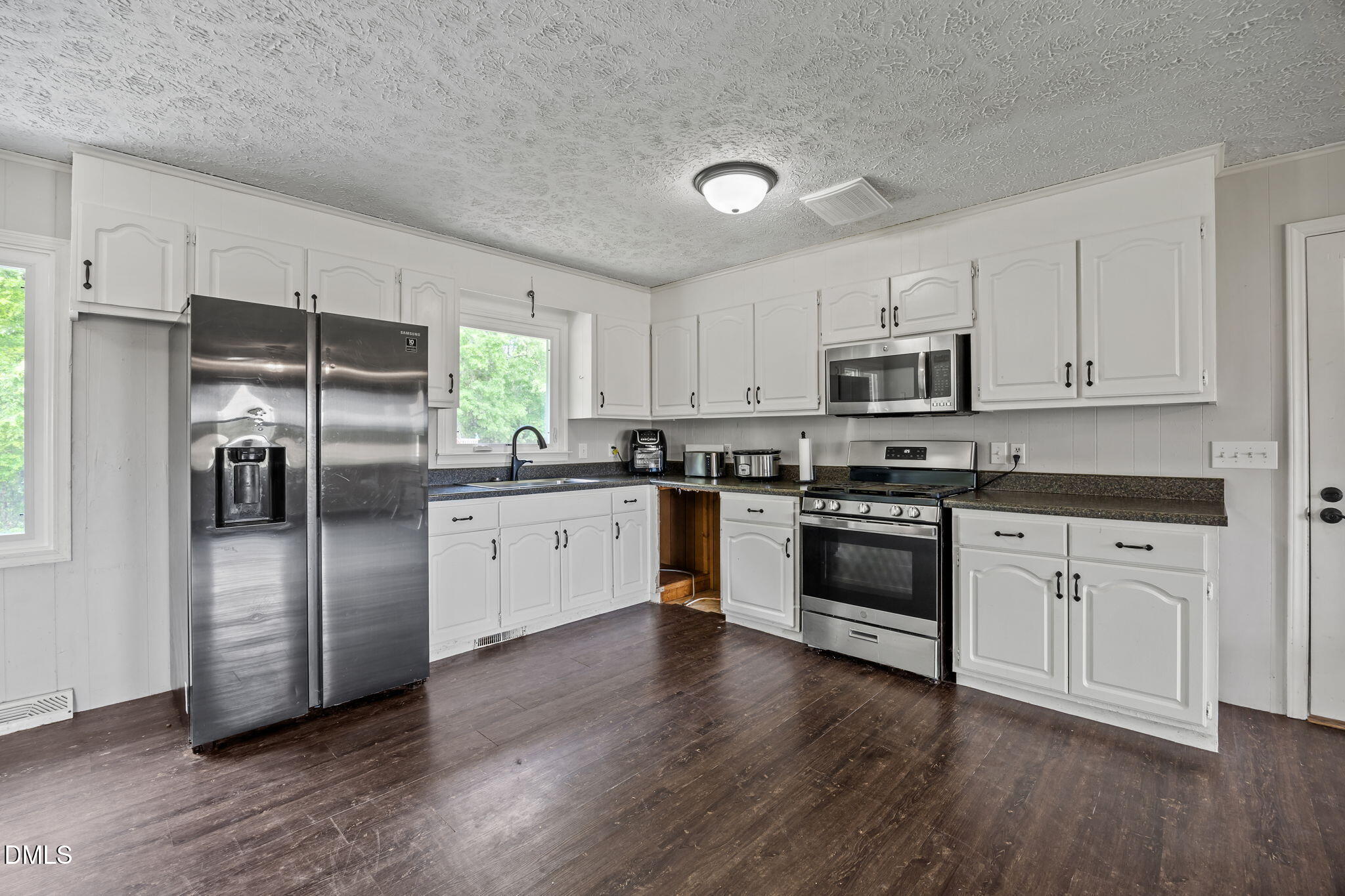 786 Dick Holeman Road Timberlake, NC 27583 - Photo 2 of 44 a kitchen with granite countertop white cabinets and stainless steel appliances
