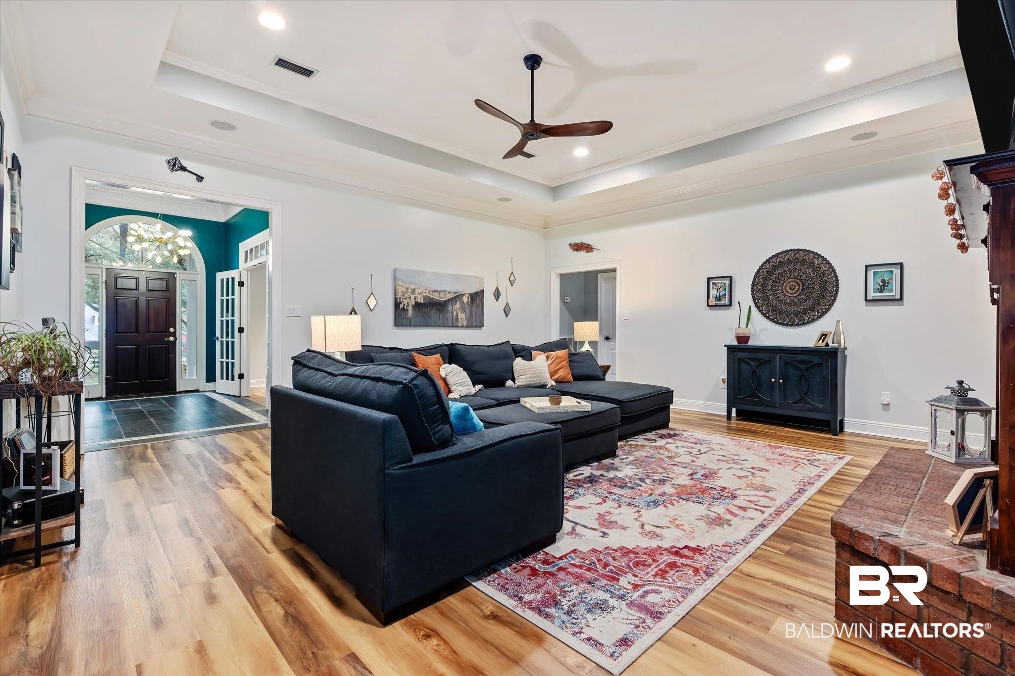3600 Russells Lane Mobile, AL 36619 - Photo 4 of 43 Living room with crown molding, ceiling fan with notable chandelier, hardwood / wood-style floors, and a tray ceiling