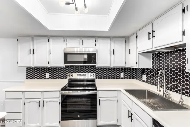 a kitchen with granite countertop a stove sink and cabinets