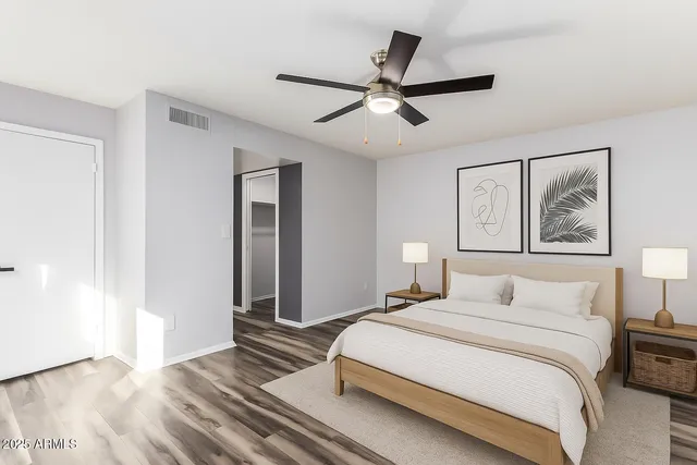 a bedroom with a large bed and a chandelier