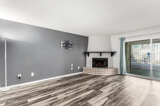 a view of a livingroom with a fireplace and window