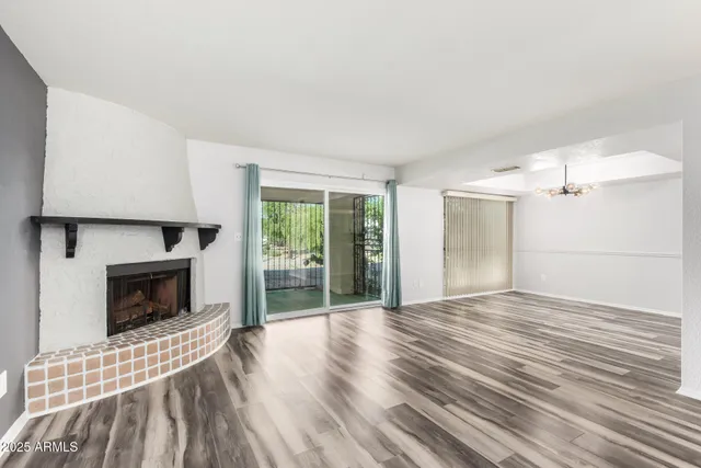 a view of empty room with wooden floor and fireplace