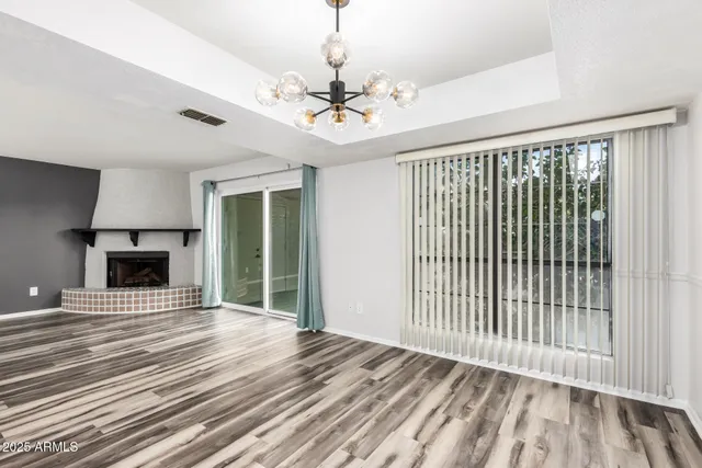 a view of an empty room with a fireplace and a window