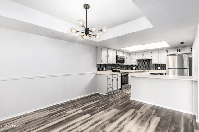 a kitchen with a refrigerator and white cabinets