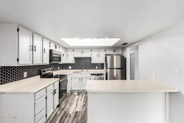 a kitchen with stainless steel appliances granite countertop a stove refrigerator sink and cabinets