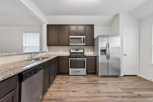 a kitchen with granite countertop a refrigerator and a stove