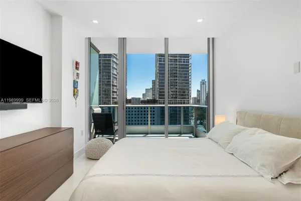 a bedroom with a large bed and a flat screen tv