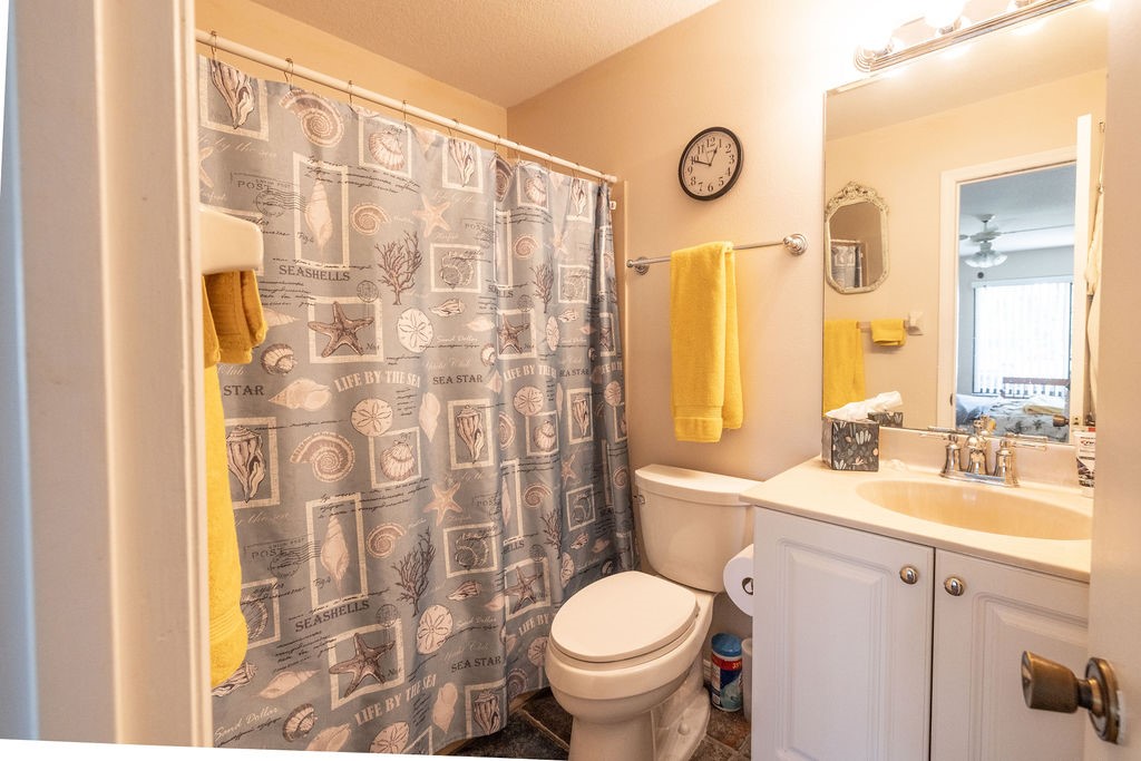 5740 Marina Drive, Unit 2 Sebastian, FL 32958 - Photo 11 of 24 a bathroom with a granite countertop toilet sink and a shower