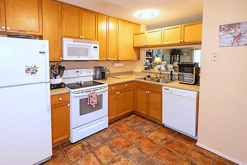 5740 Marina Drive, Unit 2 Sebastian, FL 32958 - Photo 5 of 24 a kitchen with stainless steel appliances granite countertop a stove a sink and a refrigerator