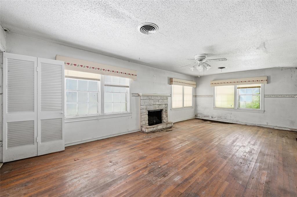 3722 North 27th Street Waco, TX 76708 - Photo 10 of 20 an empty room with wooden floor fireplace and windows