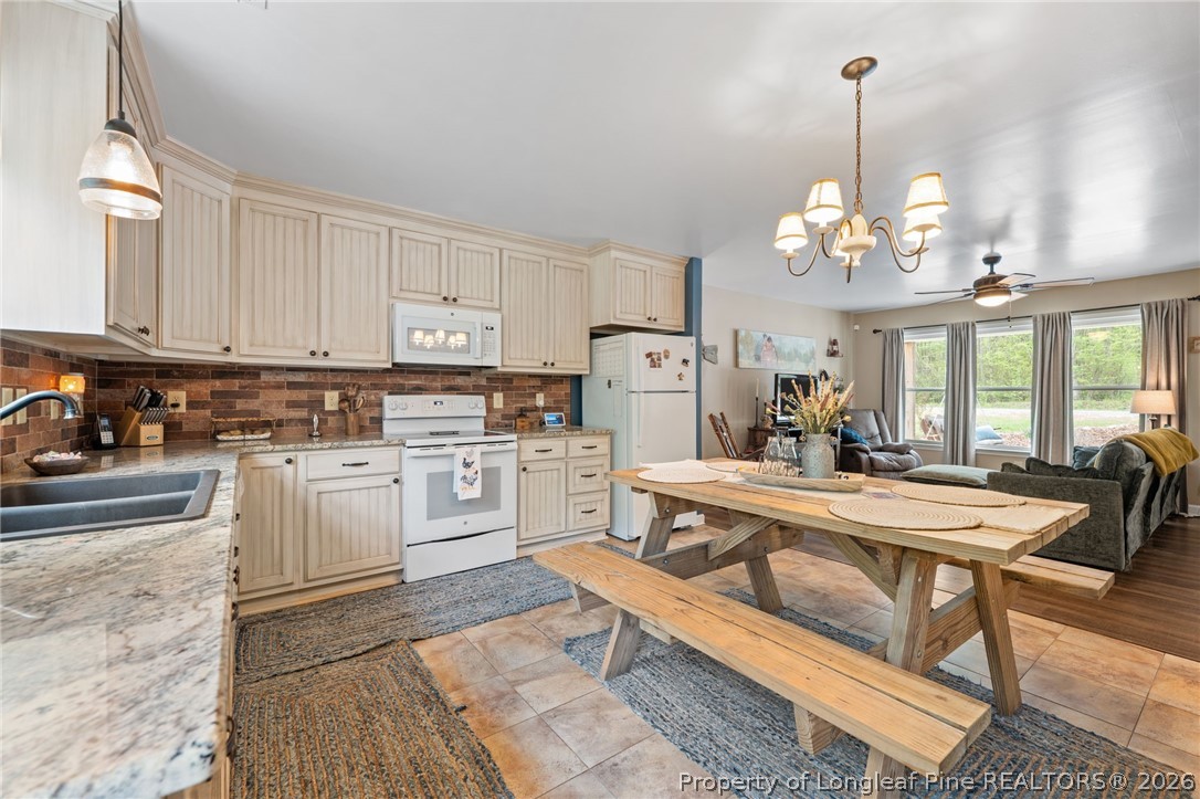 186 Lewis Brown Road Bennett, NC 27208 - Photo 14 of 48 a large white kitchen with white cabinets and stainless steel appliances