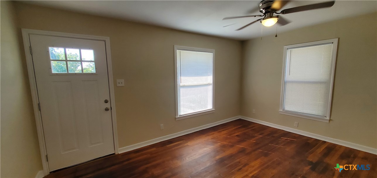 1709 South 7th Street Temple, TX 76504 - Photo 5 of 12 an empty room with wooden floor cabinet and windows