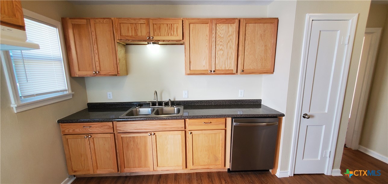 1709 South 7th Street Temple, TX 76504 - Photo 6 of 12 a kitchen with granite countertop wood cabinets and a sink