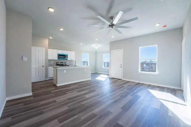 a kitchen with a sink a stove top oven and white cabinets
