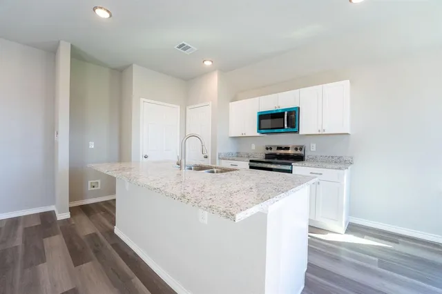 an empty room with wooden floor and a ceiling fan