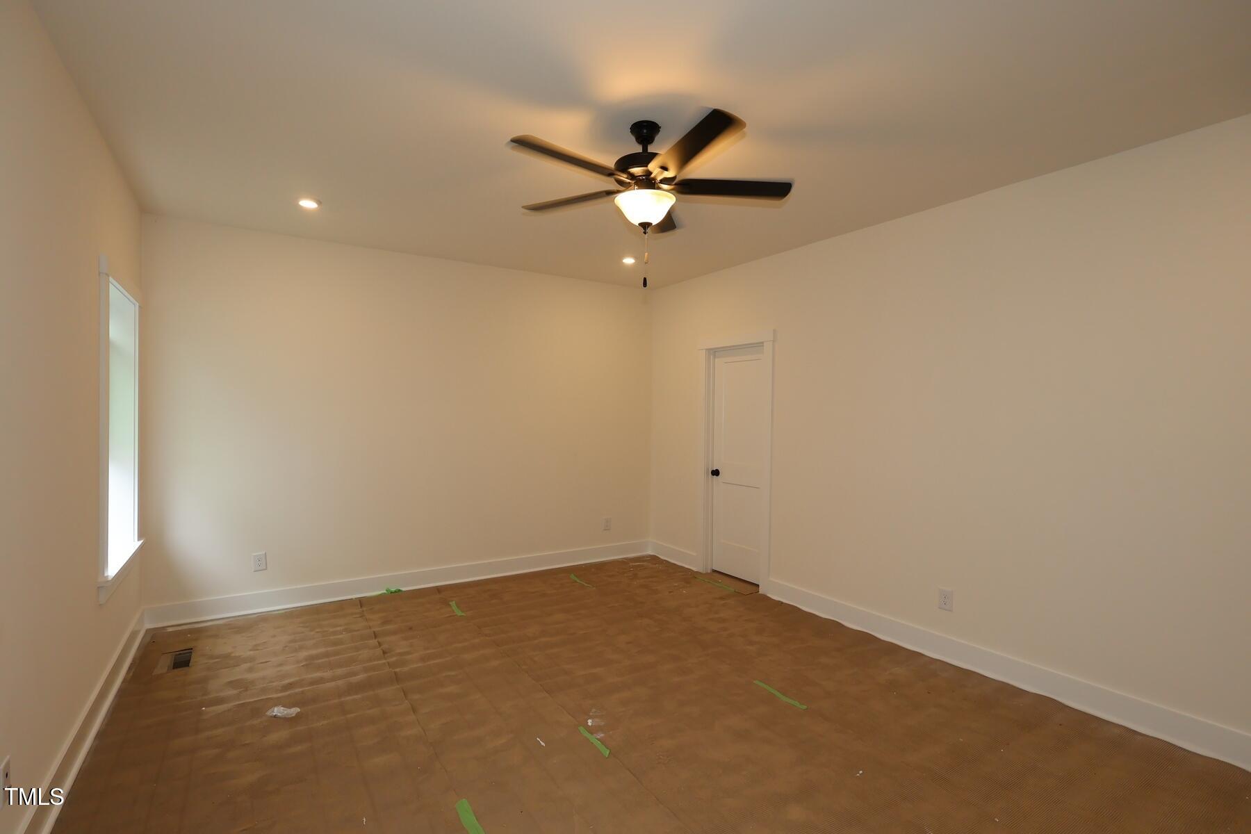 1124 Opal Lane, Unit 88 Durham, NC 27705 - Photo 17 of 27 an empty room with a window and a ceiling fan