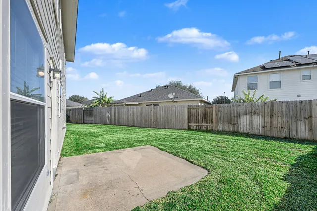 a view of a backyard with wooden fence