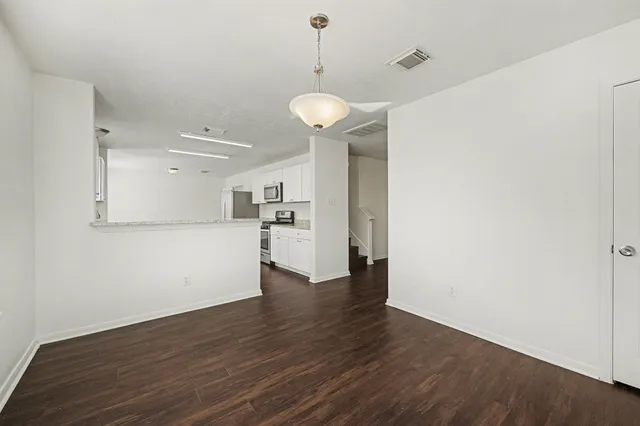 a view of a kitchen with wooden floor and a large window