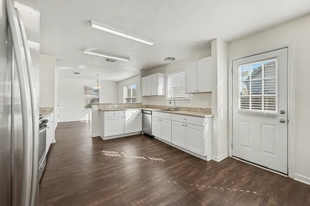 a kitchen with white cabinets and white appliances