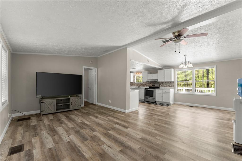 1670 Azelea Lane Gainesville, GA 30507 - Photo 5 of 33 an empty room with windows a flat screen tv and kitchen view