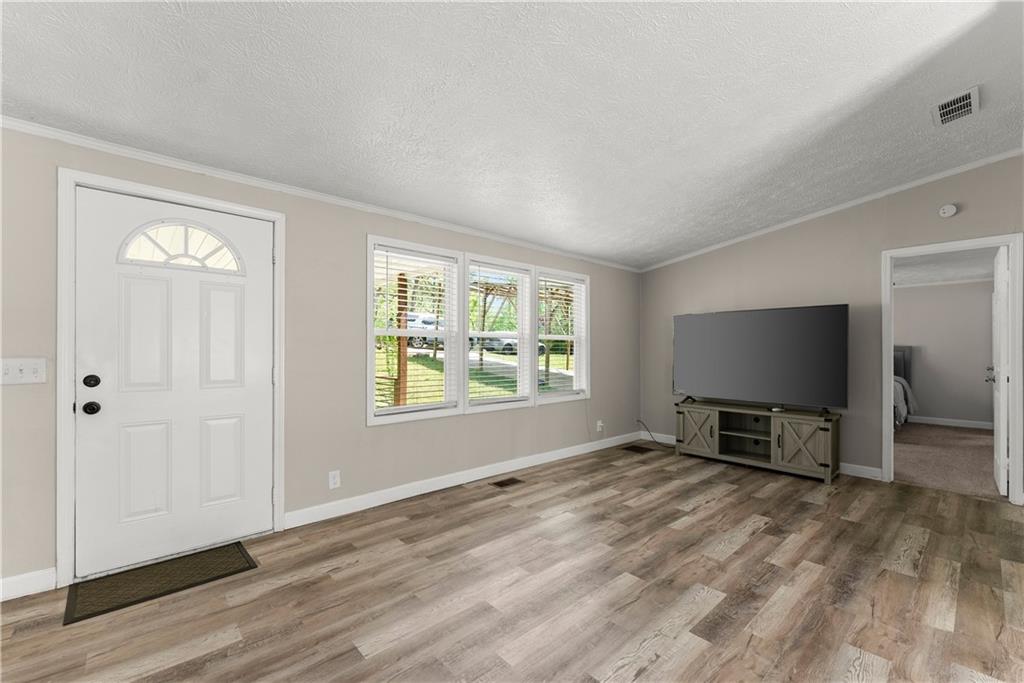 1670 Azelea Lane Gainesville, GA 30507 - Photo 7 of 33 an empty room with windows flat screen tv and wooden floor